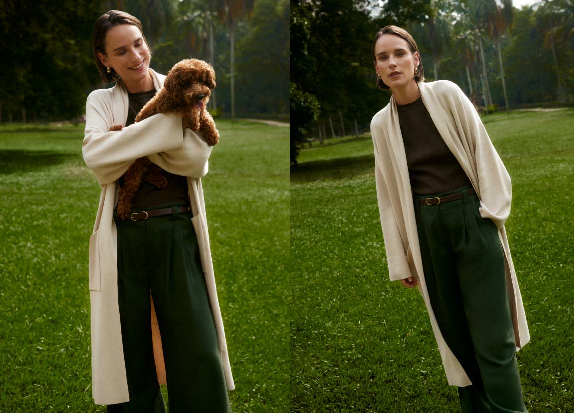 modelo posando com look em preto e cardigan off-white