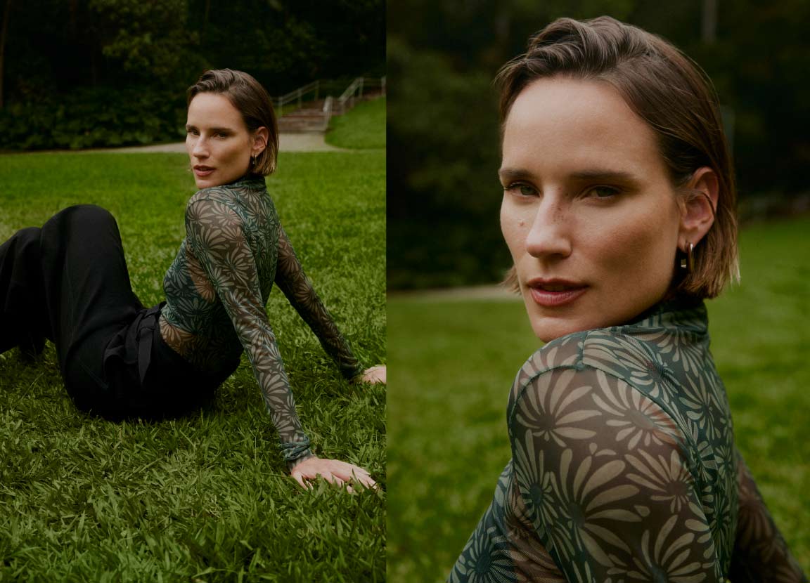 modelo posando com blusa transparente estampada e calça preta