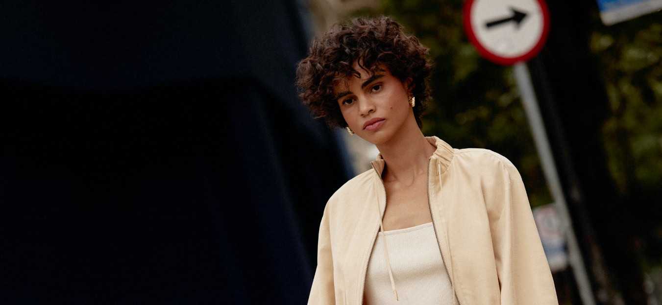 modelo com jaqueta e blusa em tons de bege representando o estilo contemporanêo