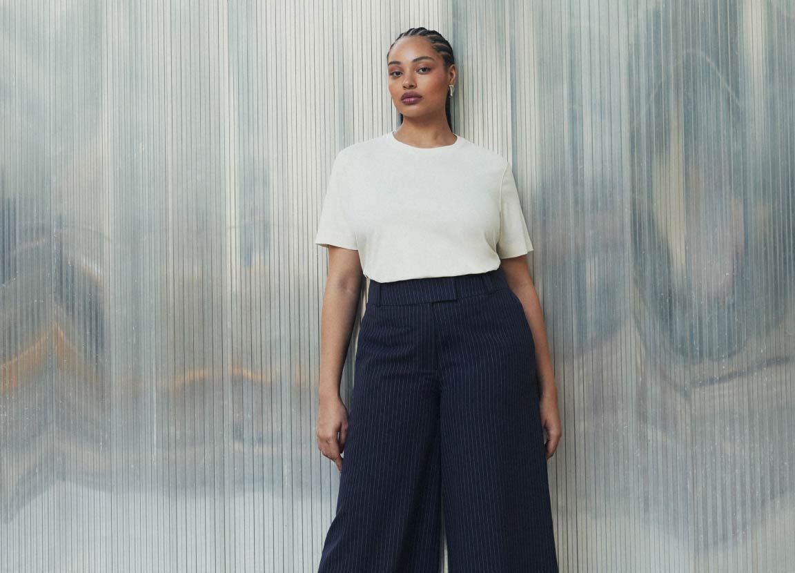 modelo com look com calça alfaiataria e camiseta branca