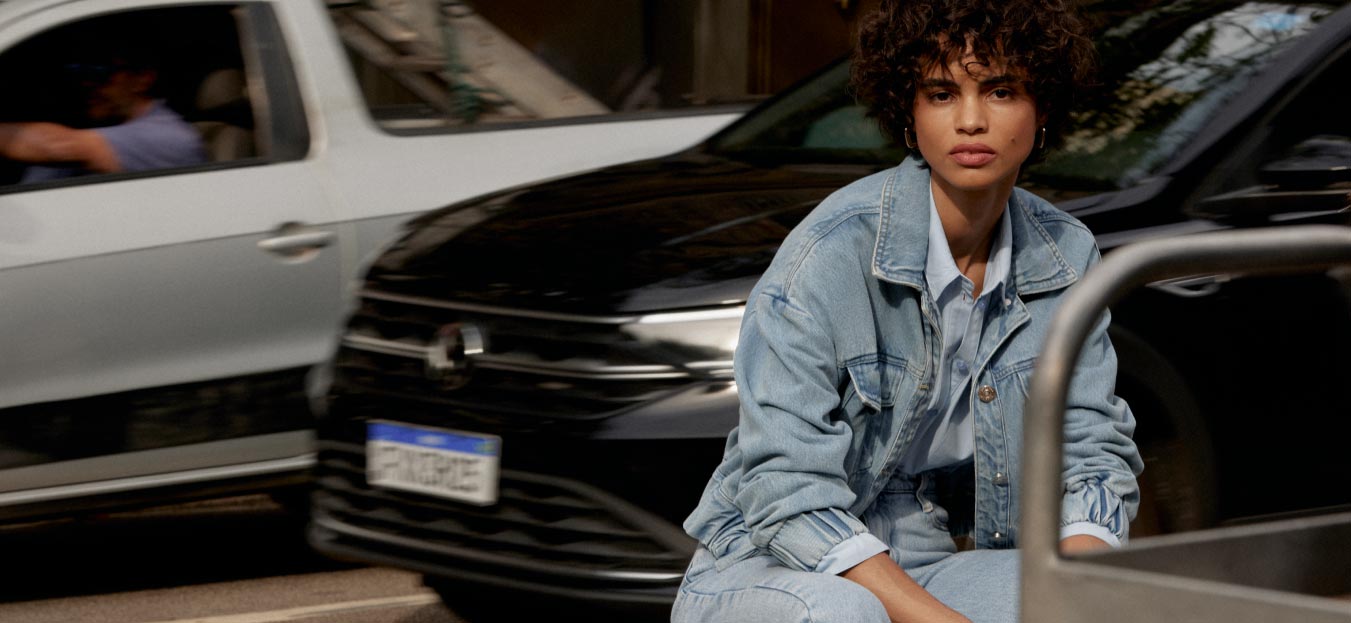 modelo com look all jeans sentada em rua