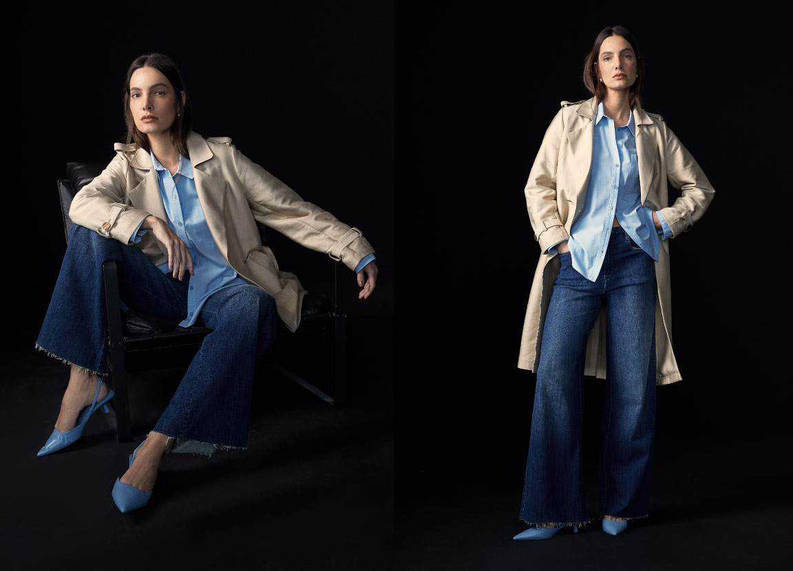 modelo posando com casaco robusto, camisa social azul e calça jeans