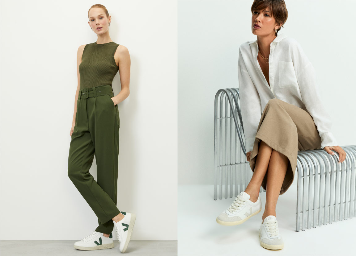 Duas modelos usando looks com tênis Veja. Uma veste calça e blusa verde, e a outra saia bege e camisa branca.